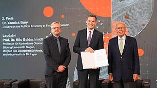 Der Zweiplatzierte Yannick Bury mit dem Laudator Nils Goldschmidt und Gratulanten Randolf Rodenstock