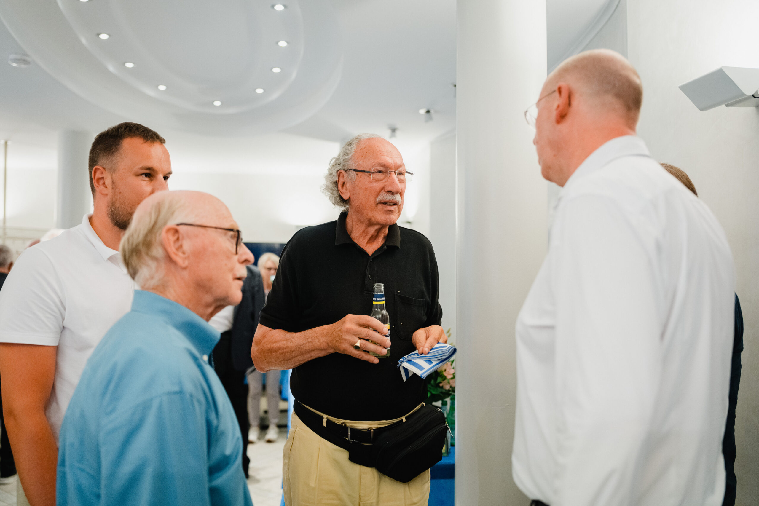 Prof. Holger Magel und Prof. Dirk Schmidt tauschen sich mit weiteren Gästen beim Empfang des Wissenschaftlichen Abendforum des Roman Herzog Instituts zur Publikationsvorstellung „Recht als Waffe“ aus.